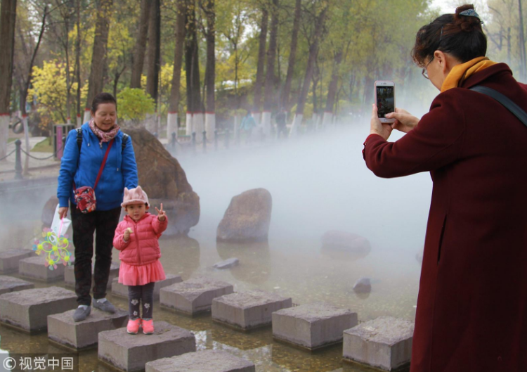 公園人造噴霧營(yíng)造“仙境” 游客駐足拍照