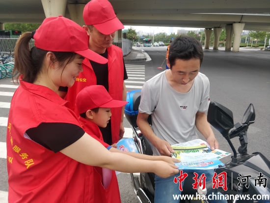 志愿者們?yōu)檫^往行人發(fā)放綠色出行宣傳單。連柏梁 攝